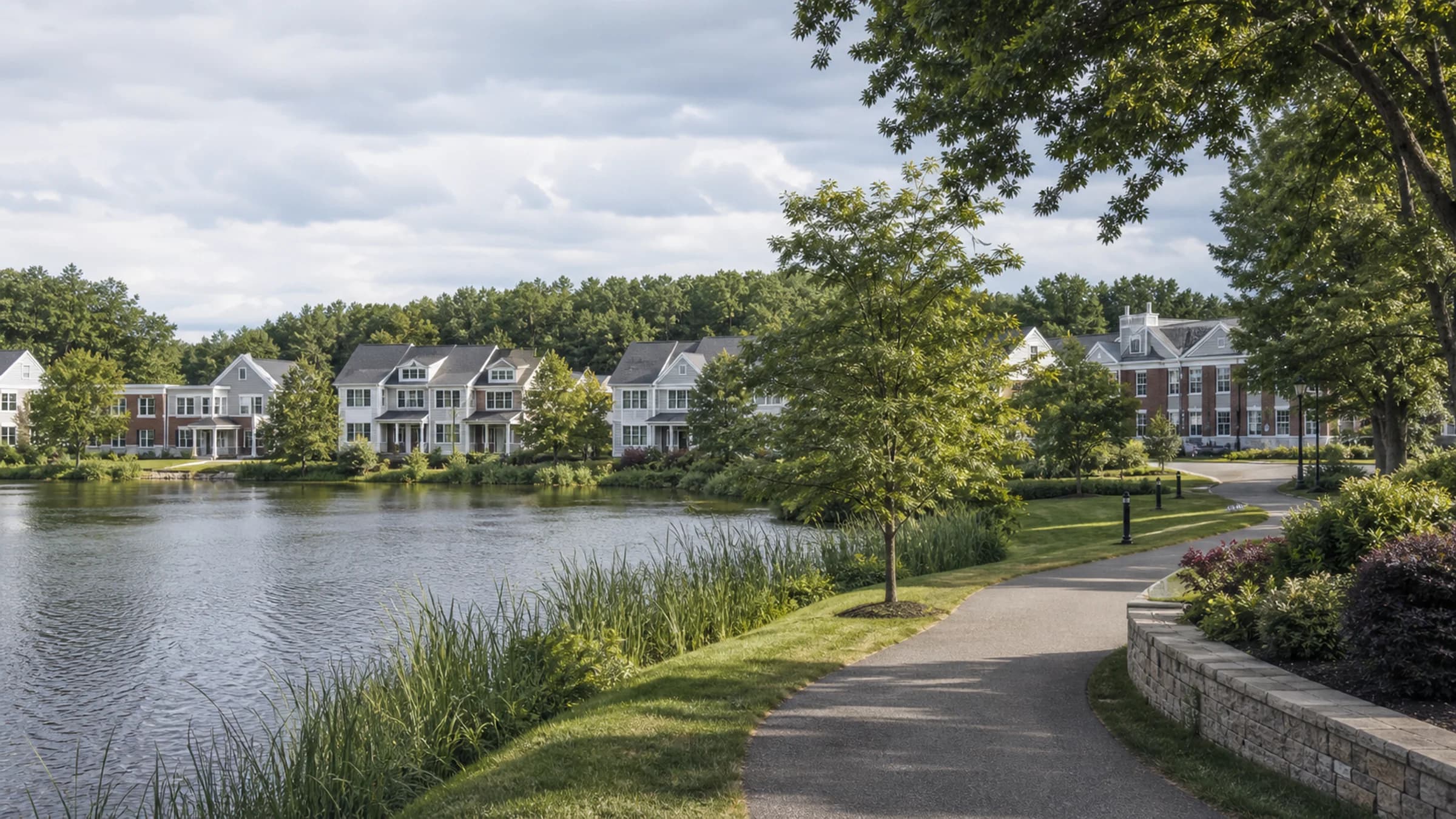 Modern active-adult residences near a tree-lined pond path